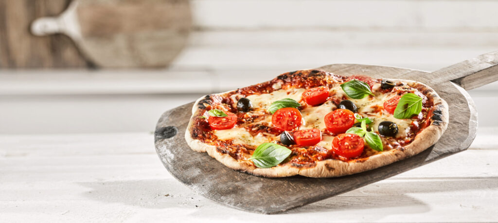 Mediterrán pizza mozzarellával, koktélparadicsommal, fekete olívabogyóval és friss bazsalikommal